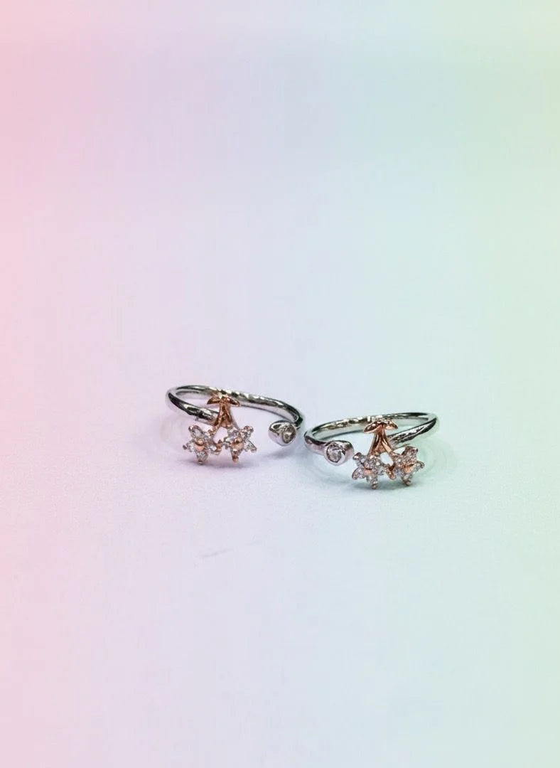 Pair of toe rings with floral designs on a gradient background