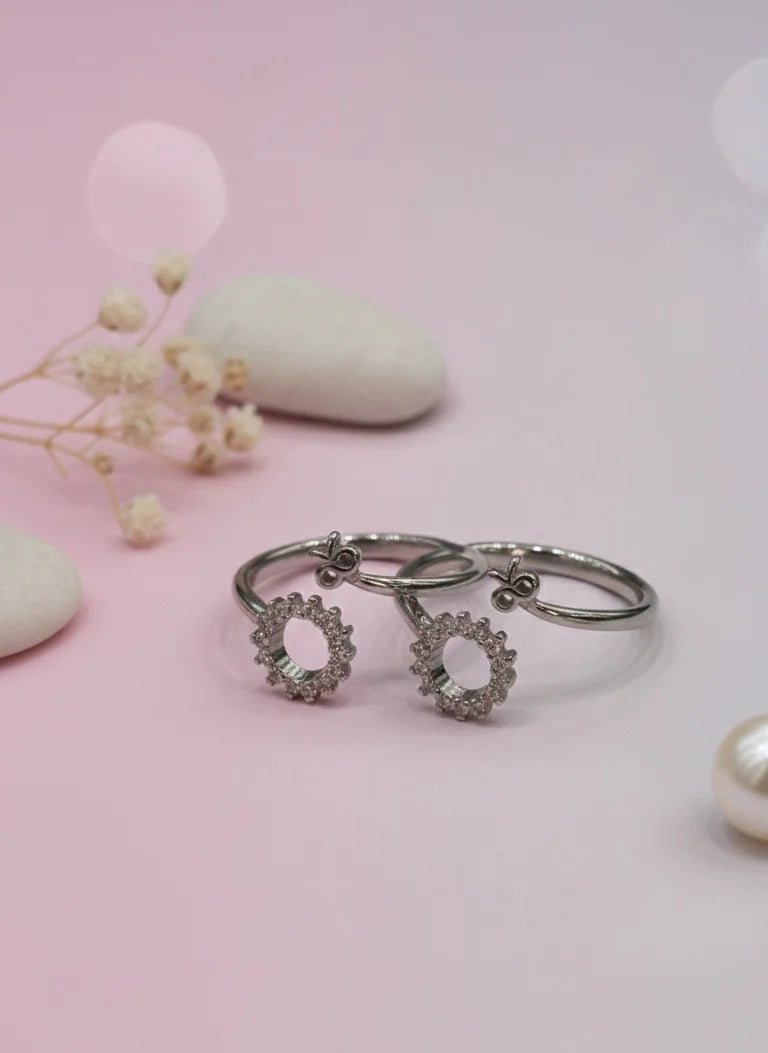 Silver toe ring with floral designs on a pink background