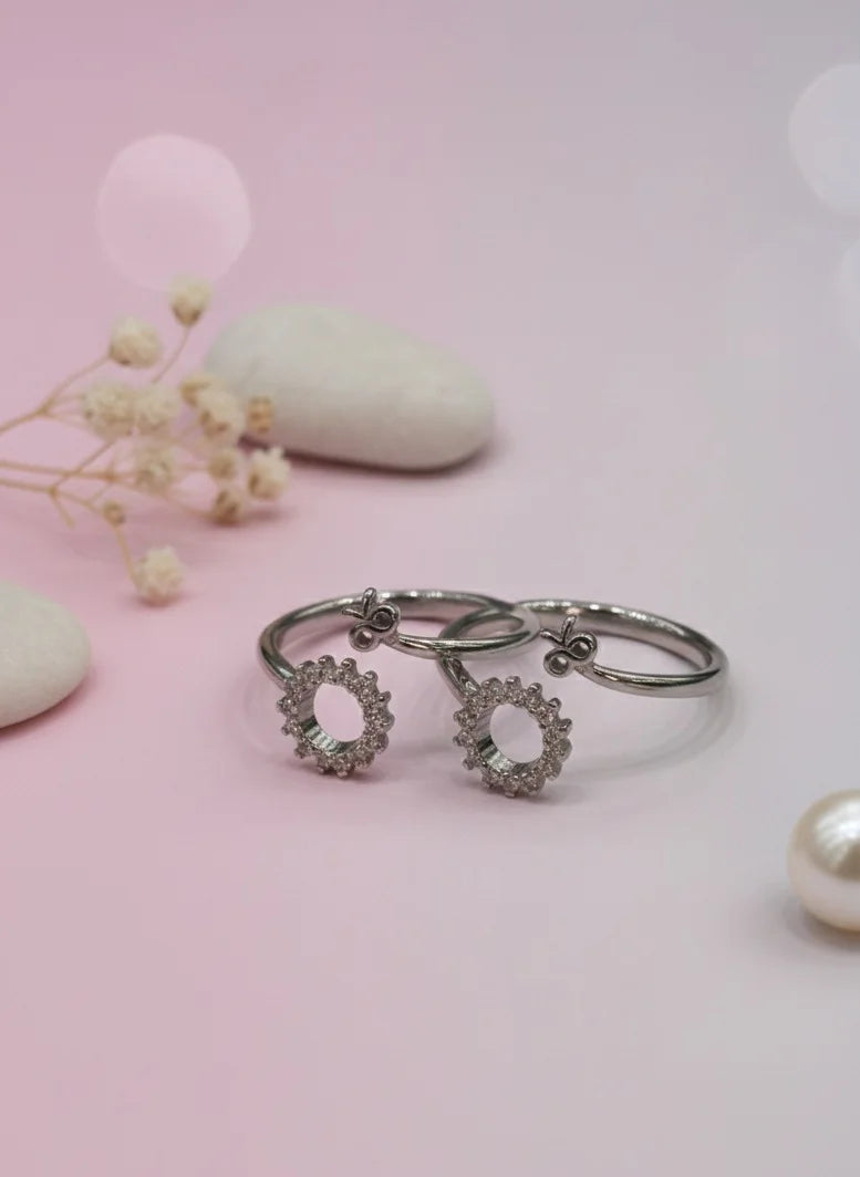 Silver toe ring with floral designs on a pink background