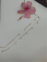 Anklet on a white surface with a pink flower