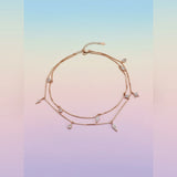 Rose gold anklet with small diamonds on a gradient background