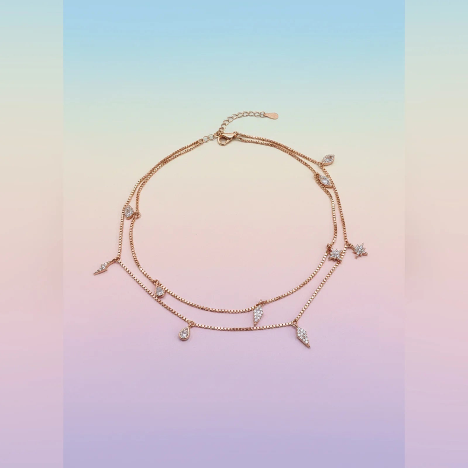 Rose gold anklet with small diamonds on a gradient background