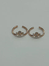 Rose gold ear rings with floral designs on a light gray background