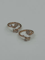Pair of rose gold toe rings with small diamonds on a light gray background