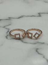 Two rose gold toe  rings with square designs on a marble surface