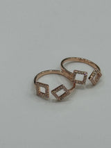 Rose gold toe ring with diamond-shaped designs on a light gray background