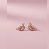Pair of rose gold leaf-shaped toe rings on a pink background