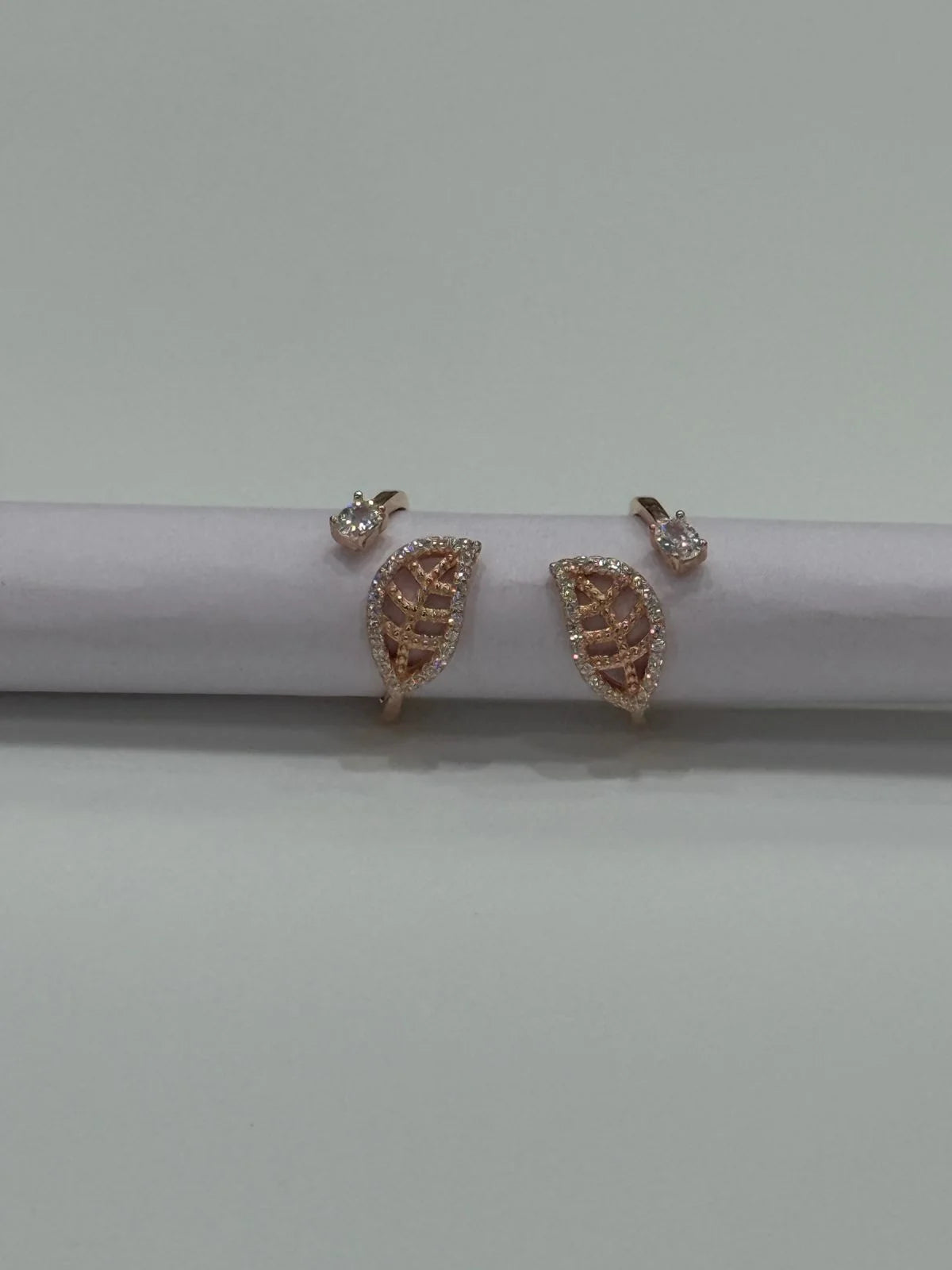 Rose gold toe rings on a white surface with a light gray background