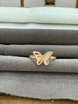 Gold butterfly ring on a stack of fabric swatches