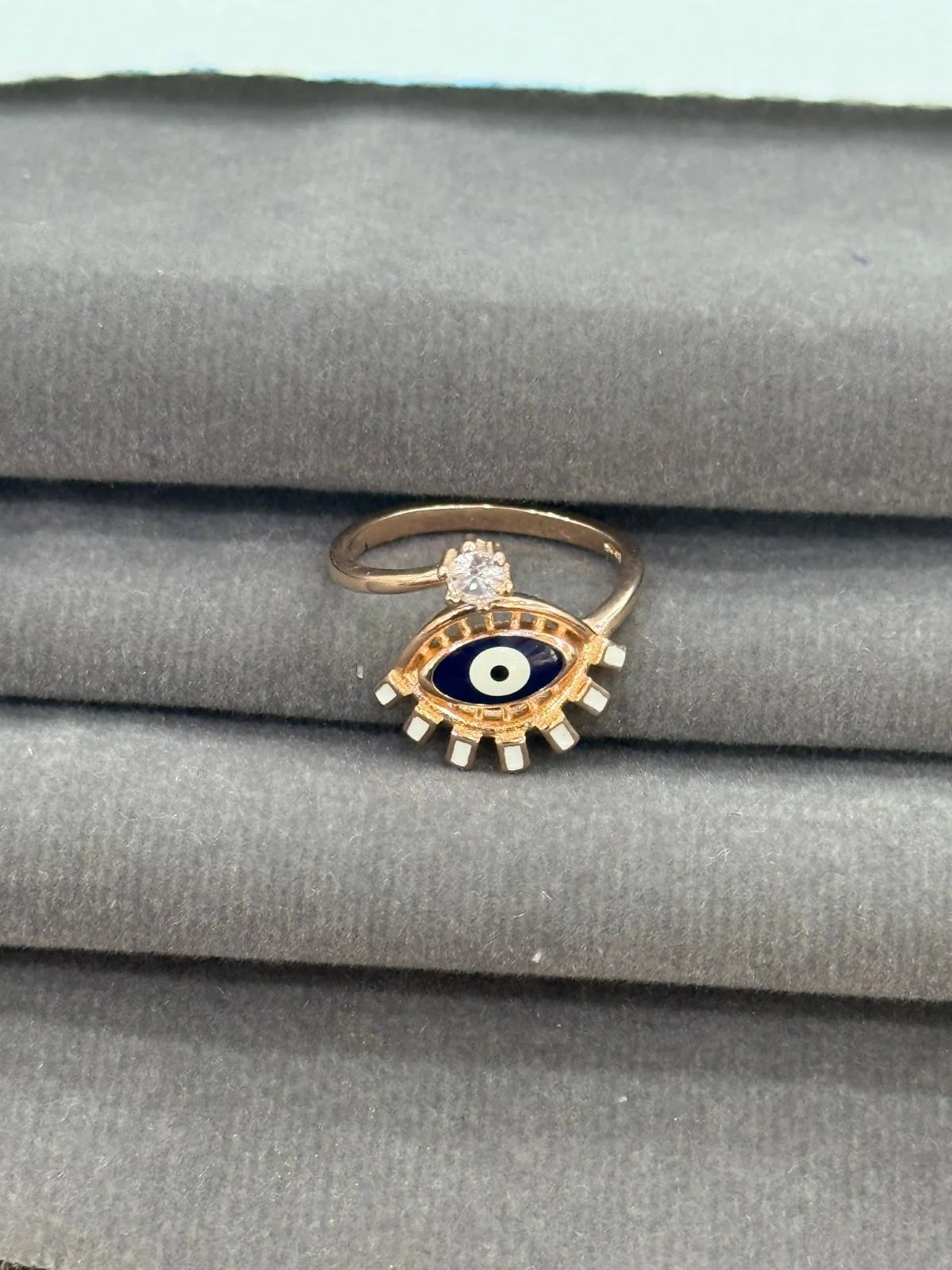 Ring with eye design on a gray fabric background