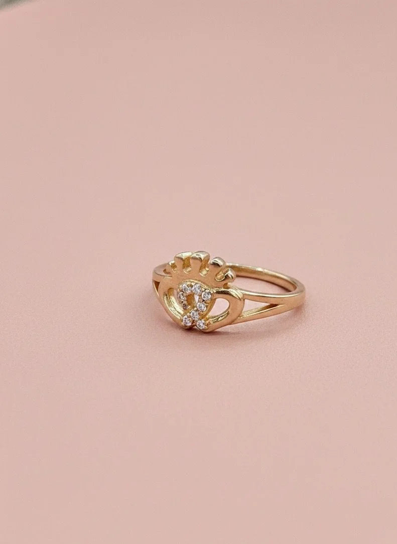Gold ring with a yellow gemstone on a pink background