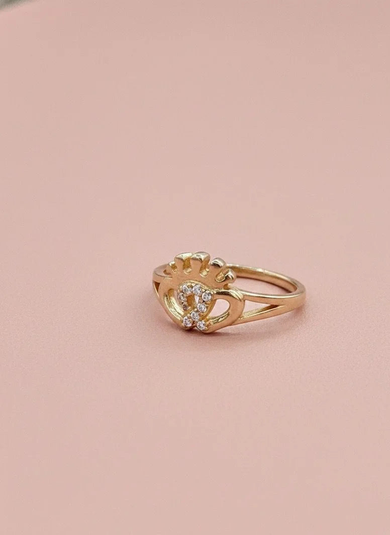 Gold ring with a stone on a pink background