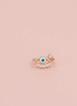 Rose gold ring with a blue gemstone on a pink background