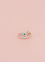 Rose gold ring with a blue gemstone on a pink background