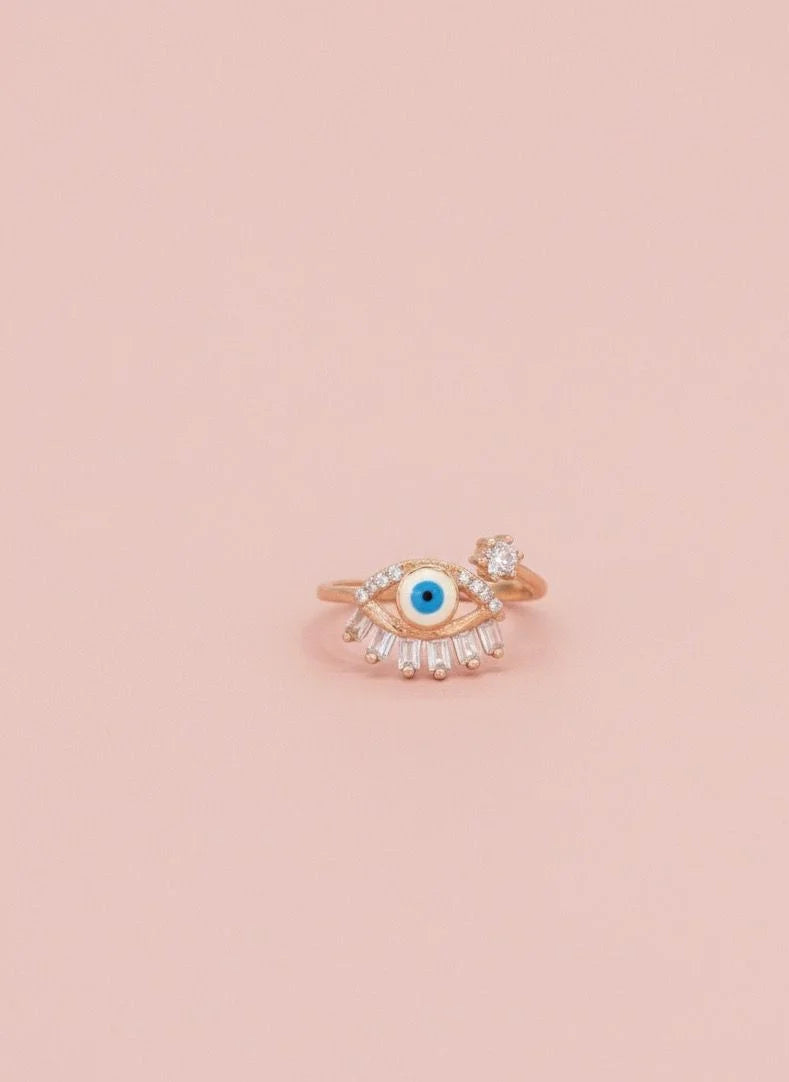 Rose gold ring with a blue gemstone on a pink background