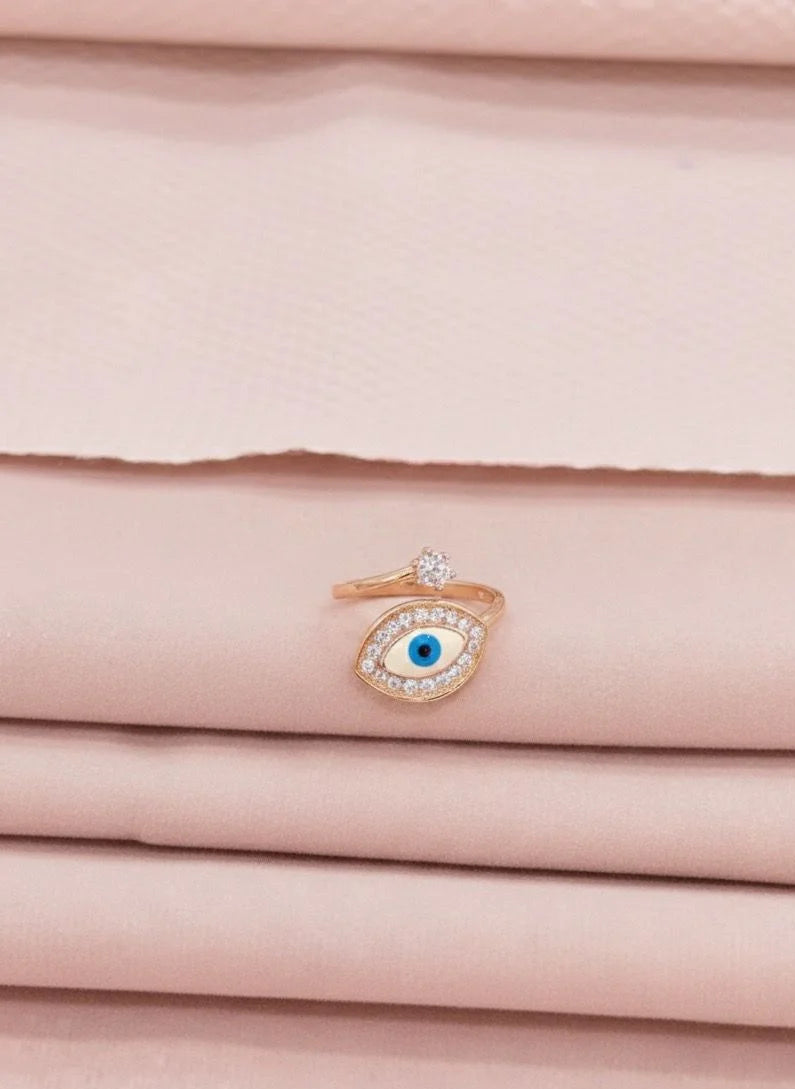 Rose gold ring with a blue gemstone on a pink fabric background