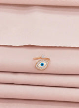 Rose gold ring with a blue gemstone on a pink fabric background