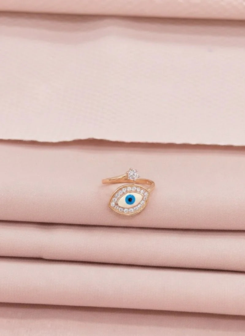 Rose gold ring with a blue gemstone on a pink fabric background