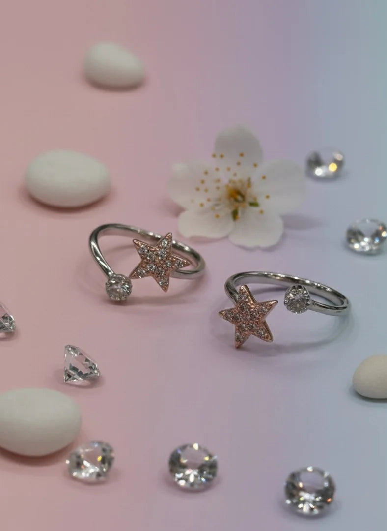 Star-shaped toe rings with diamonds on a pink and white gradient background
