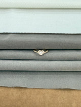 Stack of fabric swatches in various colors with a heart-shaped ring on top.