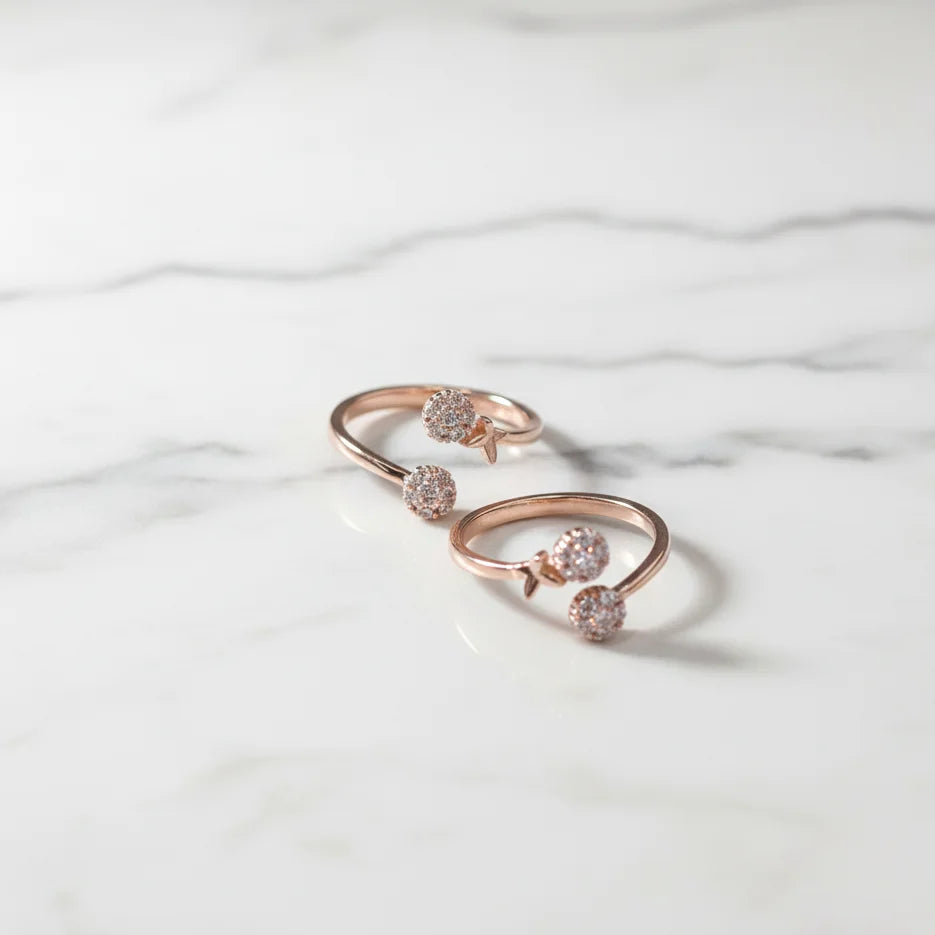 Rose gold toe ring with gemstones on a marble surface