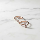 Rose gold toe ring with embedded stones on a marble surface