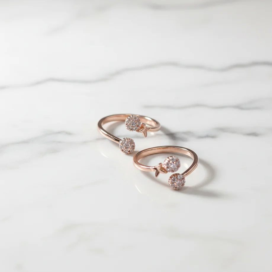 Rose gold toe ring with gemstones on a marble surface