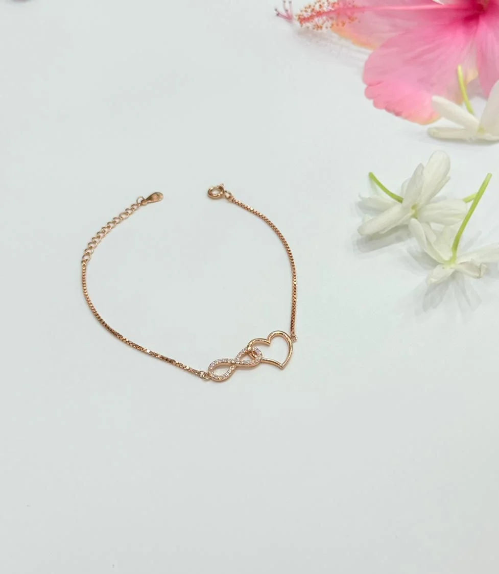 Rose gold bracelet on a light surface with flowers