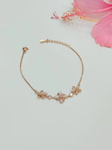 Rose gold bracelet with floral designs on a light background