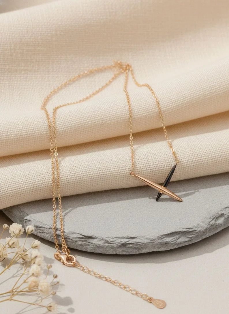 Rose gold necklace with a unique pendant on a textured surface
