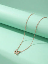 Rose gold necklace on a light green background