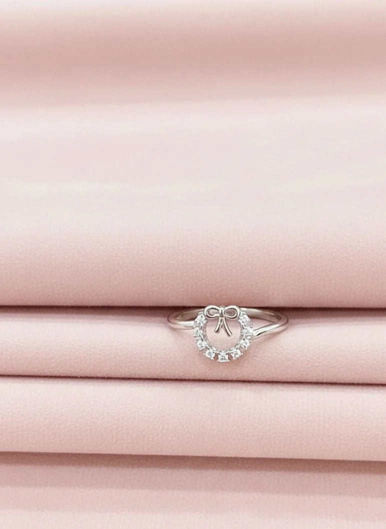 Silver ring with a heart-shaped stone on pink fabric
