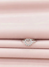 Silver ring with a heart-shaped stone on pink fabric