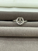 Silver ring with diamond accents on a gray surface