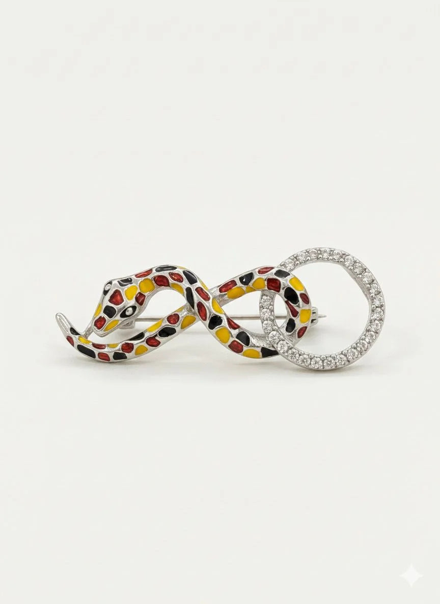 Decorative pendants with snake design and gemstones on a white background