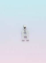 Silver pendant with letter 'H' on a light gradient background