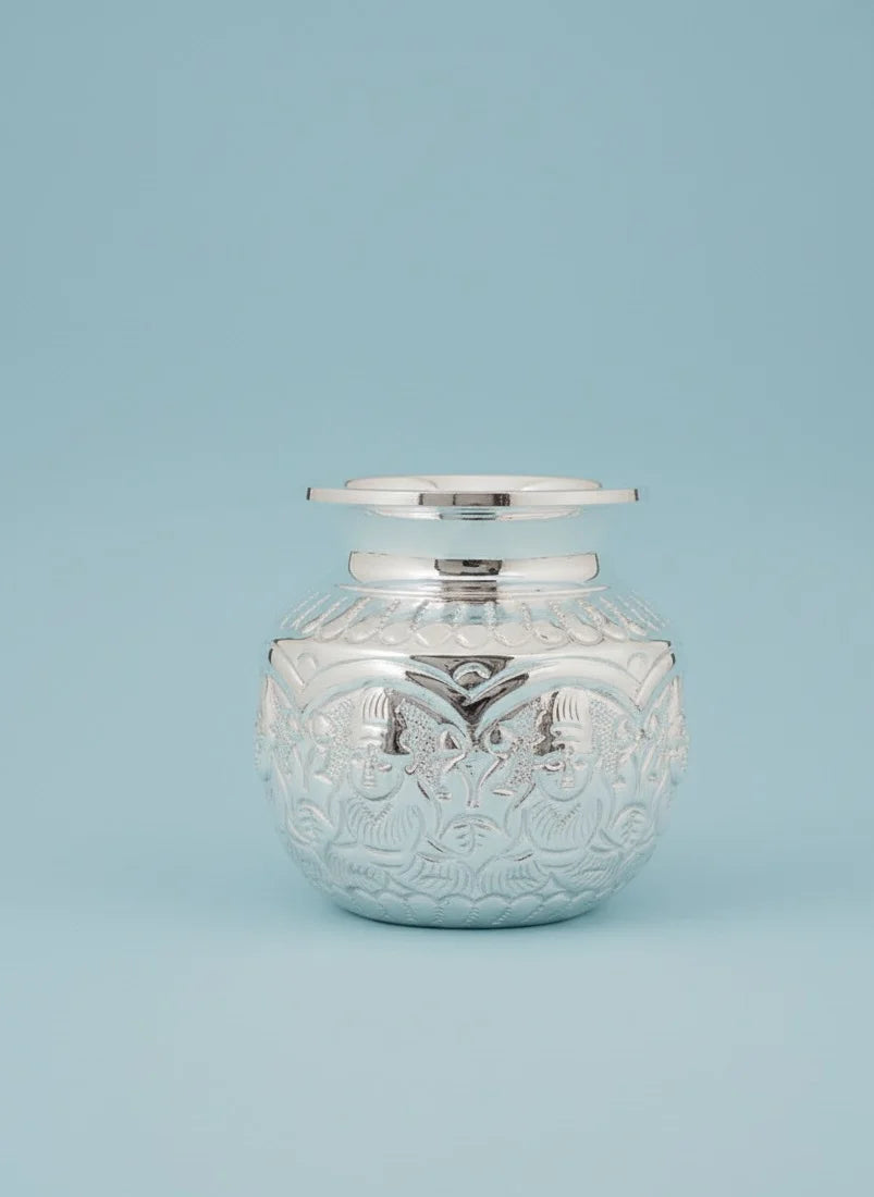 Decorative glass jar with silver lid on a light blue background