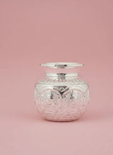 Decorative glass jar with silver lid on a pink background