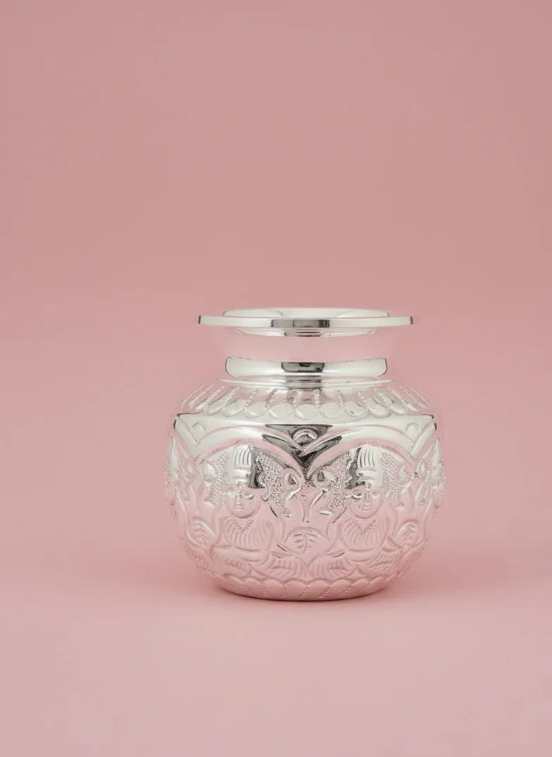Decorative glass jar with silver lid on a pink background