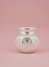 Decorative glass jar with silver lid on a pink background