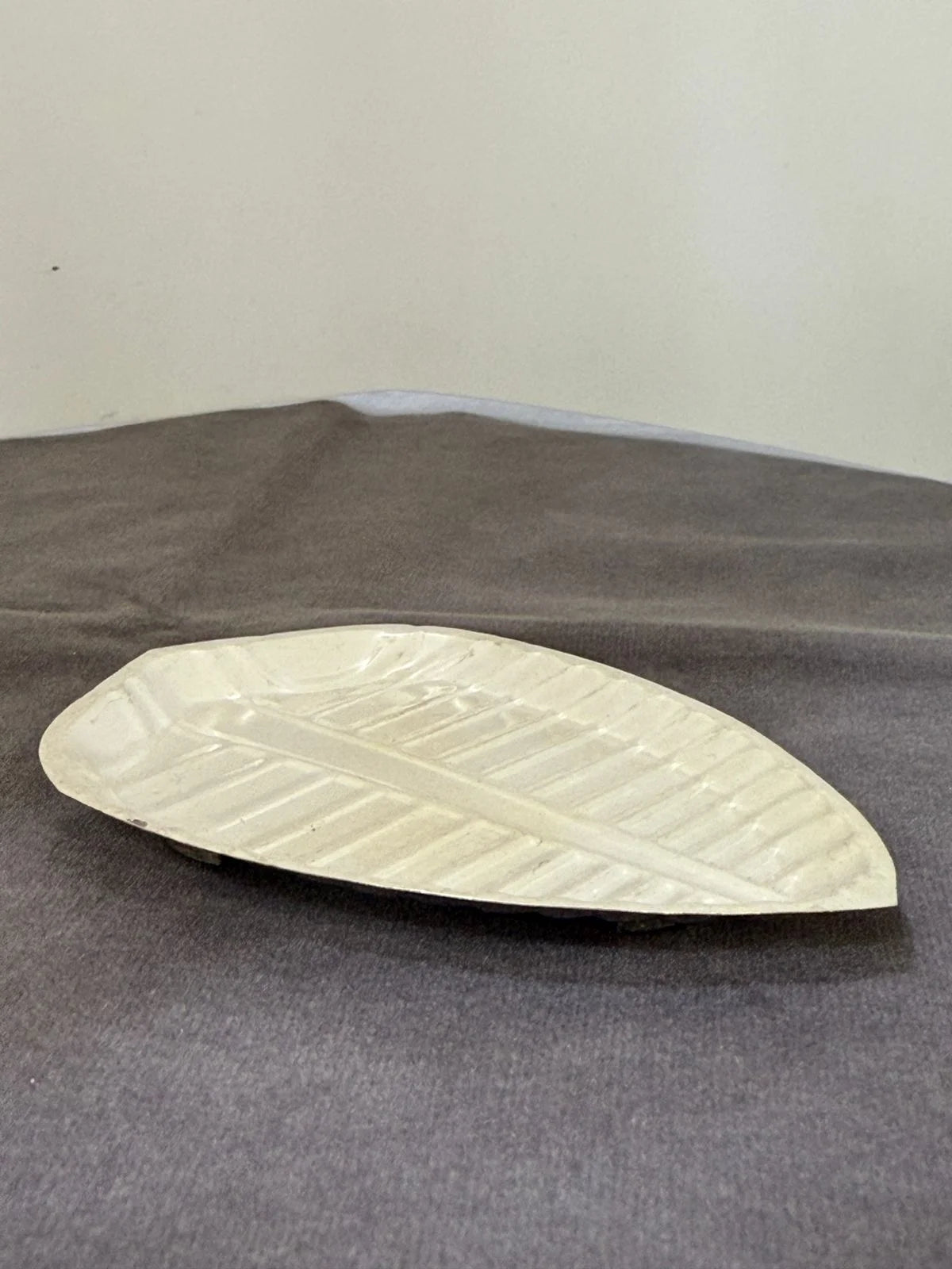 White ceramic dish on a gray surface with a plain background