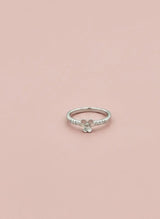 Silver ring with a floral design on a pink background