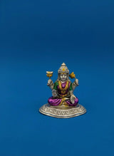 Decorative figurine of a seated figure with colorful attire on a blue background