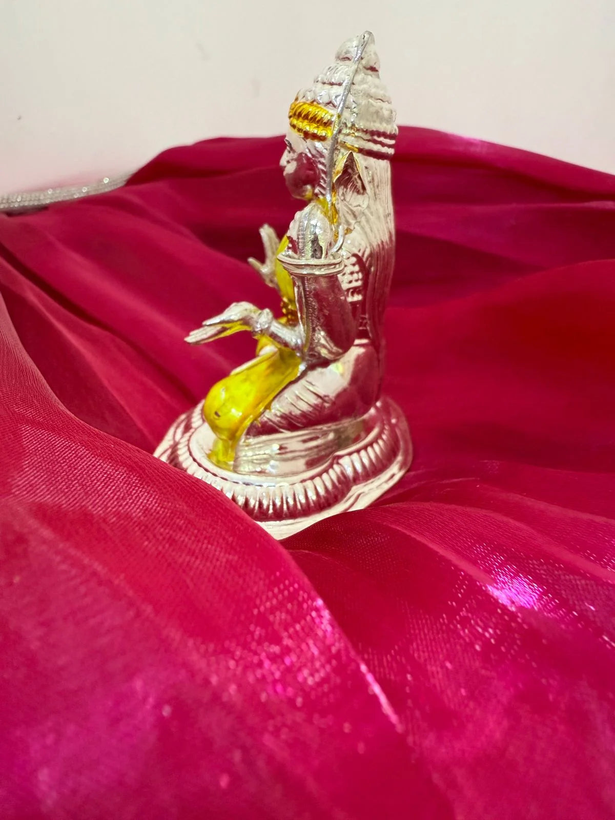 Silver and gold statue on a red fabric background