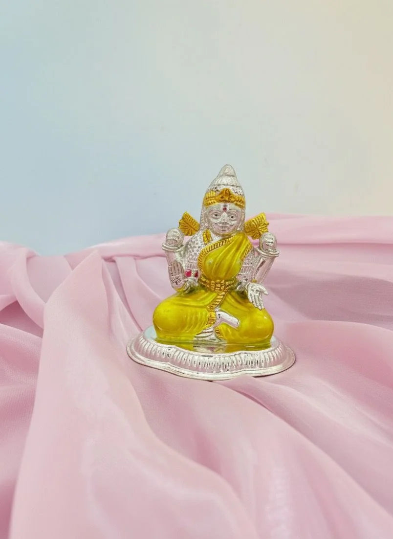 Decorative statue of a seated figure with yellow garment on pink fabric