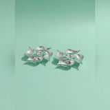 Pair of silver leaf-shaped earrings on a light green background