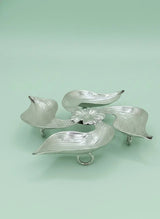 Silver leaf-shaped caddy on a light green background