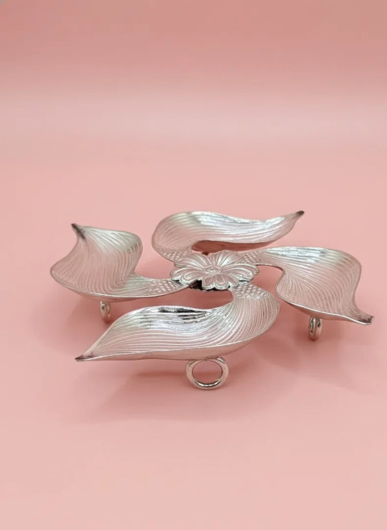 Silver leaf-shaped dish on a pink background