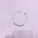 Silver bracelet with floral design on a light purple background