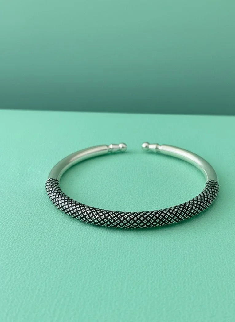 Silver textured bangle on a teal background